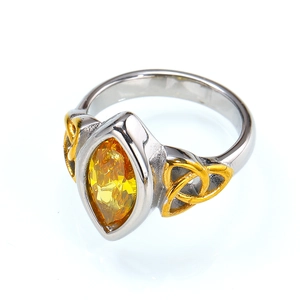 Detail of marquise cut yellow gemstone and golden Celtic knot on a titanium ring