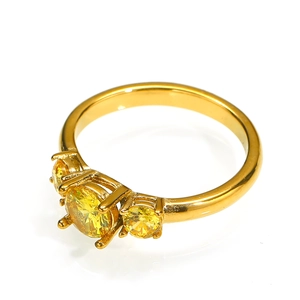 Detailopname van drie gele ronde stenen in een vierklauwzetting op een gouden ring
