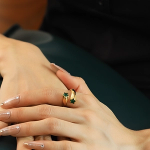 Luxurious 18K gold star zircon ring featuring two green star-shaped crystals on a model hand