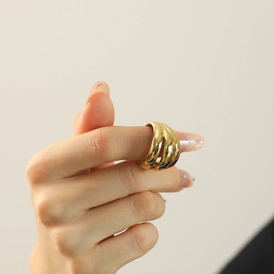 Polierter goldener mehrlagiger Wellenring im gestapelten Design am Finger getragen