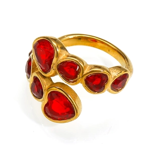 Detail of interlocking golden heart ring featuring multiple red cubic zirconia stones