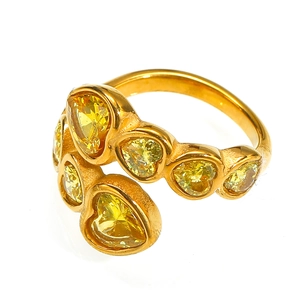Detail of overlapping gold ring featuring multiple heart-shaped yellow cubic zirconia stones