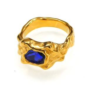 Detailaufnahme des goldenen Lava-Rings mit unregelmäßiger Struktur und blauem Edelstein