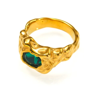 Detail eines Goldrings mit Lavatextur und eingesetztem sechseckigem grünem Stein