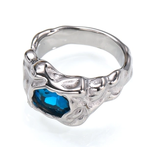 Nahaufnahme eines silbernen Rings mit Faltenoptik und einem großen ovalen blauen Edelstein