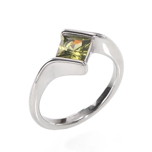 Macro detail of silver steel ring featuring square cut olive green zircon in a sleek bezel setting