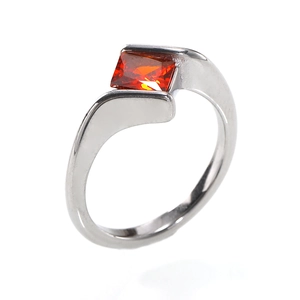 Detailed macro view of silver ring with orange rectangular gemstone and polished finish