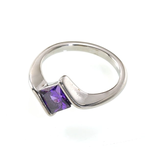 Detail of silver steel ring with square purple zircon inlay and bypass band design
