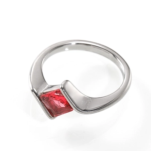 Macro detail of a silver-toned ring with a square red gemstone in a sleek spiral setting