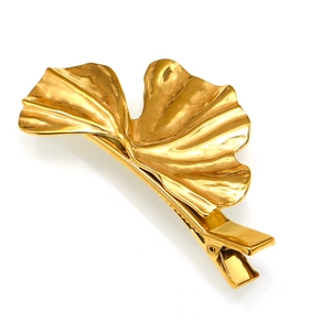Close-up of golden ginkgo leaf metal hair clip with detailed leaf texture and alligator clip