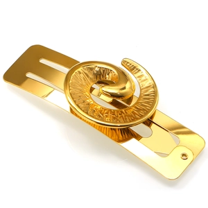 Detailed close-up of a gold-plated ocean-style hair clip featuring a textured spiral disc