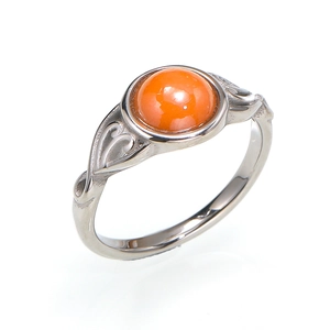 Detailed macro view of vintage hollow heart patterns and orange gemstone on a silver ring