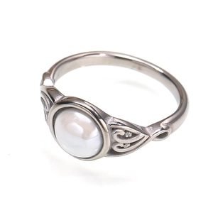 Macro view of vintage silver steel ring with round cabochon stone and hollow carving