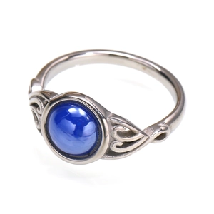 Detailed side view of silver titanium steel ring with hollow vintage pattern and blue gemstone