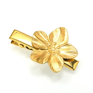 Detailed macro view of the golden flower hair clip with radiant petal textures and a center bead