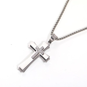 Detail showing the layered stainless steel cross pendant with cubic zirconia inlay on chain
