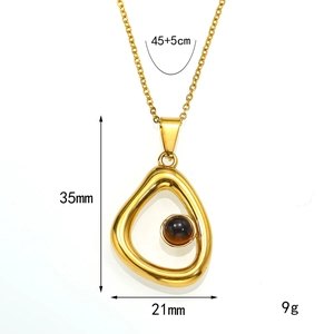 Elegante gouden ketting met driehoekige hanger en ronde edelsteen aan een schakelketting