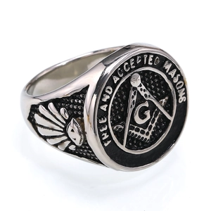 Gros plan sur une bague chevalière maçonnique en argent avec gravure détaillée Free Mason