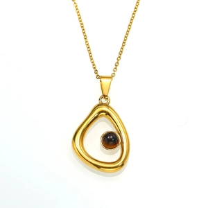 Detailopname van een gouden ketting met een onregelmatige hanger en donkere kraalinleg