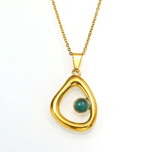 Franse stijl gouden ketting met onregelmatige hanger en groene edelsteen op wit decor