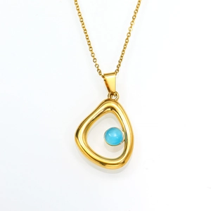 Macro-opname van gouden druppelvormige hanger met lichtblauwe edelsteen aan de ketting
