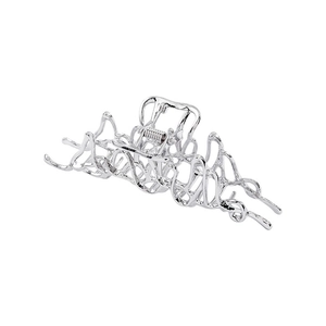 Detail of silver liquid metal hair claw clip with irregular lava texture on white background