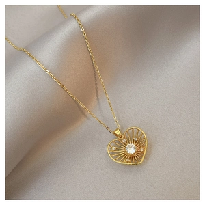 Close-up of golden heart pendant necklace with radial gold wires and sparkling diamond