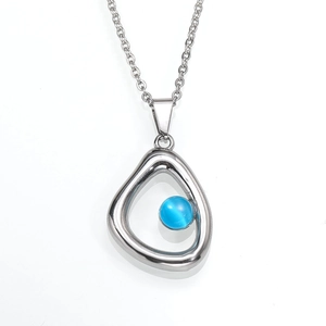 Elegante zilveren ketting met onregelmatige hanger en blauwe edelsteen op witte achtergrond
