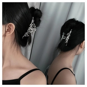 Close-up of a silver liquid-metal wavy hair claw clip worn in a sleek hairstyle