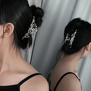 Irregular liquid silver metal hair claw clip shown from side and back view on dark hair
