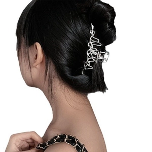 Irregular liquid silver metal hair claw clip with mirror finish on model dark hair