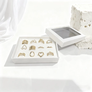Detail of 11-piece minimalist gold ring set with heart and leaf designs in a white box