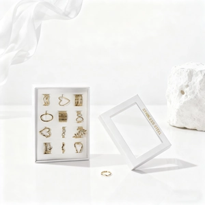 Close-up of 12-piece gold stainless steel ring set in a white window gift box