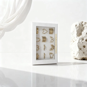 12-piece gold stainless steel ring set with diverse designs in a white window gift box
