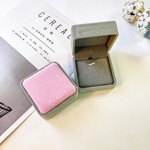 Minimalist velvet jewelry organizer boxes in pink and grey displayed with props