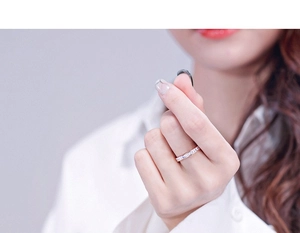 Gros plan d'une bague éternité en titane or rose avec zircons sur une main