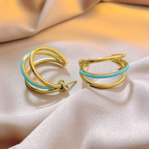 Three-layer mint blue and gold C-shaped hoop earrings on elegant satin fabric
