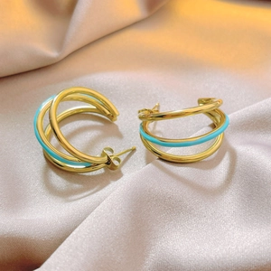 Three-layer C-shaped gold earrings with mint green enamel on champagne silk background