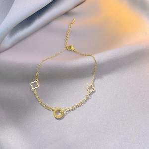 Fußkettchen aus Titanstahl mit Kleeblatt und graviertem LOVE-Ring auf grauem Seidenhintergrund