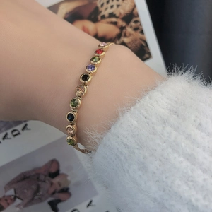 Goldenes Titanstahl-Armband mit mehrfarbigen Kristallen am weiblichen Handgelenk