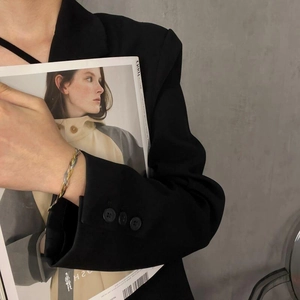Bracciale a catena intrecciata a tre toni in oro e argento indossato da donna