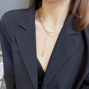 Chic multi-layer stainless steel necklace with pearls and ruler pendant on a model