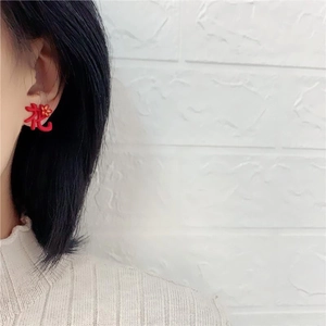 Boucles d'oreilles créatives rouges à caractères chinois portées par un mannequin sur blanc