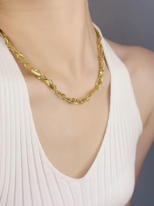 Détail du collier à double chaîne dorée torsadée avec maillons plats et ovales