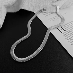 S-shaped flat silver herringbone snake chain necklace on a black leather background