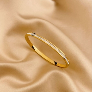 Elegant gold titanium steel bracelet with sparkling crystals on champagne silk fabric