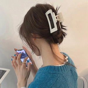 Close-up of white matte geometric hair claw clip used for elegant ponytail hairstyle