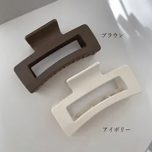 Close-up of matte brown and ivory square hair claw clips with secure grip teeth