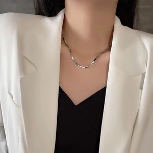 Polished silver titanium steel necklace with rectangular tube links worn by a model