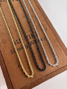 Detail of multi-color rope chains in gold, black, and silver on a vintage wood box